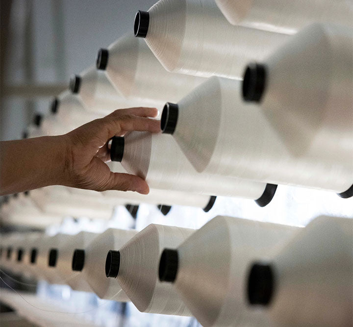 Close-up of premium yarn spools used in the craftsmanship and manufacturing of PranaSleep mattresses.